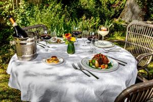 BellenavesHostellerie du Chateau Bellenaves的餐桌,带食物盘和一瓶葡萄酒