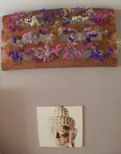 萨达Cozy & Quiet Apartment.的墙上架子上的花的照片