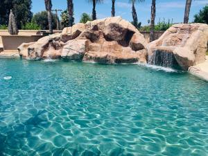 里弗赛德LuxHome Suites的一个带瀑布和岩石的游泳池