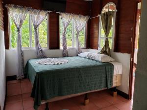 San FelipeHotel y Restaurante La Cabaña el Viajero的配有2扇窗户的客房内的1张床