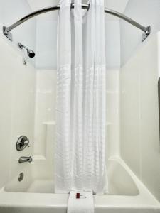 昆西AmericInn by Wyndham Quincy的带浴缸的白色淋浴帘