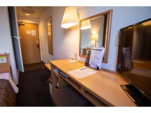 半田AZ INN HANDA INTER - Vacation STAY 69370v的酒店客房配有书桌和电视。