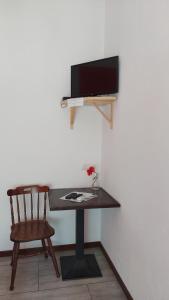 瓦尔玛德雷拉Locanda La Tana Del Luppolo的一张桌子、椅子和墙上的电视