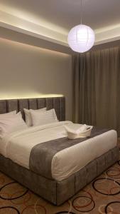 艾卜哈Golden Andalus Hotel的一间卧室配有一张带灯具的大床