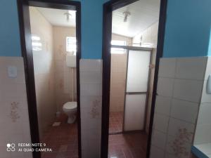 阿尔特杜尚Casa Mineira的一间带卫生间的浴室和一间带两扇玻璃门的浴室