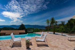 福斯迪诺沃AntiquaeLunae Casali的一个带白色椅子的庭院和一个游泳池