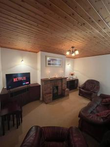 TullyrossmearanMc's View的客厅配有电视、沙发和壁炉