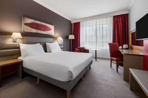 杜伦达勒姆丽笙酒店的酒店客房设有一张大床和一张书桌。