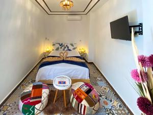 马拉喀什Riad Dar Yassine的一间卧室配有一张床和一台平面电视