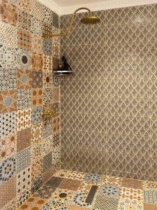 马拉喀什Riad Dar Yassine的浴室的墙壁上设有瓷砖和淋浴。