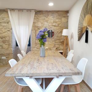 庞特维德拉Casa Elvira, terraza con fabulosas vistas的一间带木桌和白色椅子的用餐室