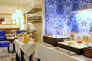 巴特克罗青根孟旅馆的餐厅配有桌椅和蓝色壁纸