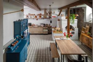 BlomeViesu nams Donas的厨房配有蓝色橱柜和木桌