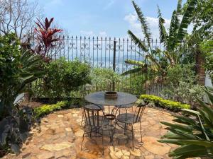 SuchitotoCasa Flor de Pajaro, vistas panorámicas increíbles al lago的花园设有围栏,配有桌椅