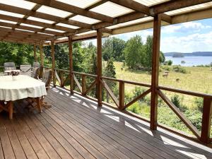 利姆福萨Holiday home RIMFORSA V的木甲板配有桌子,享有田野美景