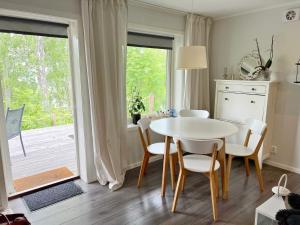 韦姆德Holiday home VÄRMDÖ V的一间配备有白色桌椅的用餐室
