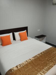 古来One World Hotel的卧室配有带橙色枕头的大型白色床