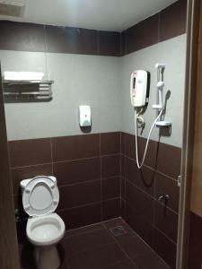 古来One World Hotel的一间带卫生间的浴室和墙上的一部电话