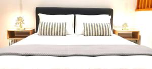 海若克利欧Urban Luxus Studio II的一间卧室配有白色床和2个床头柜