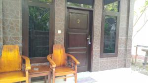 吉利特拉旺安库苏卡简易别墅民宿的门前有两把木椅