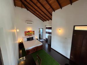 高尔拉伊鲁别墅酒店的卧室配有白色的床和绿色地毯。