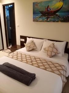 阿伯来Golden Bird Heritage的一间卧室设有两张床,墙上挂着一幅画