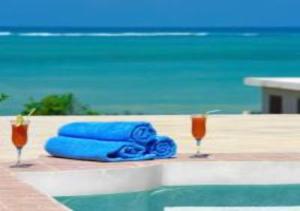 帕杰Serenity Luxury Villas的沙滩旁桌子上摆放着两条蓝色毛巾