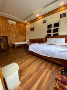 会安扫麦酒店的一间卧室设有一张大床,铺有木地板。