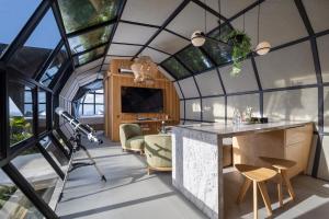 库塔Airship Bali by Alex Villas的客房设有带桌椅的大型玻璃天花板。