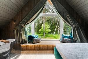 PaplatelėSOPRANO - 'Virš Ąžuolų' - Forest SPA - Horses - Lake的一间卧室设有一张床和一个大窗户