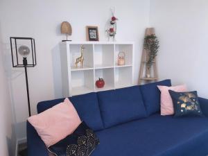 布雷斯特Cocon avec jardin terrasse privé et parking的客厅配有带枕头的蓝色沙发