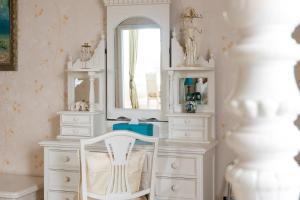 Niton魔法庄园酒店的白色梳妆台、镜子和白色椅子