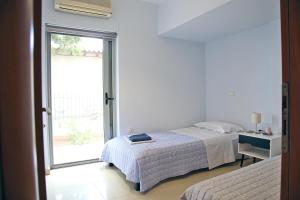 斯巴达2 Bedroom Apartment near the Athens Airport, Spata的一间卧室设有一张床和一个窗口