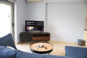 斯巴达2 Bedroom Apartment near the Athens Airport, Spata的客厅配有蓝色的沙发和电视