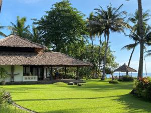特贾库拉巴厘古拉角度假屋的草场和棕榈树的房子
