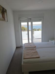 贾塞尼采Apartmani Deluxe的一间带两张床的卧室,享有海景