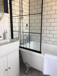 布莱顿霍夫SEAFRONT SANCTUARY Beautiful Art Deco Apartment with Stunning City & Sea Views的白色的浴室设有浴缸和水槽。