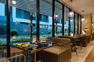 卡塔海滩Wekata Luxury的餐厅设有桌椅和大窗户。