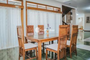 Villa Mawar Adinda Kuningan Syariah RedPartner的一间带木桌和椅子的用餐室
