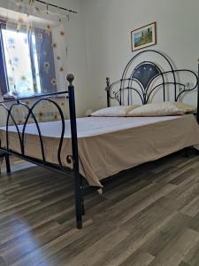 MonteluponeForesteria del Re的一间卧室配有一张黑色的床,铺有木地板