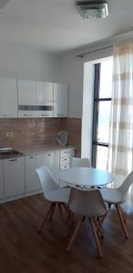 多布拉沃达Queen Apartments & Rooms的厨房配有桌子、椅子和桌子,厨房
