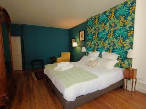 沙托鲁Maison d'hôtes de charme - Au Lys Blanc的一间卧室设有一张蓝色墙壁的大床