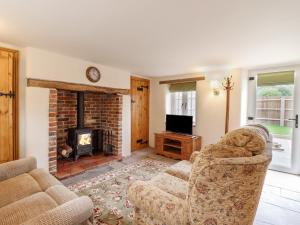 塞特福德Postbox Cottage的客厅配有两把椅子和壁炉
