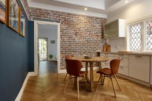 悉尼kookaburra beach house coogee的厨房配有桌椅和砖墙