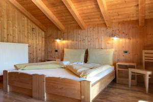 巴迪亚Paracia App Pic Pec的木制客房内的一间卧室,配有一张床