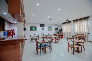 MabalacatBliss Hotel Dau的餐厅内带桌椅的用餐室