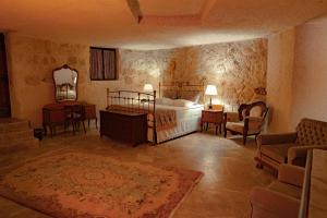 于尔居普尤纳克埃夫勒里卡帕多西亚酒店的卧室配有一张床和一张桌子及椅子