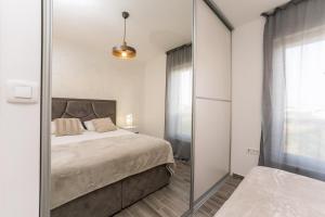 比比涅Luxury D Apartments的一间卧室配有一张床和镜子