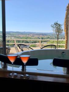 卡尔卡松Panorama Suite romantique & Spa的浴缸旁的桌子上放两杯葡萄酒