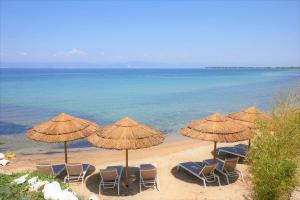 斯卡拉索提罗斯Byblos Aqua-The Sea Front Luxury Villa的海滩上的一组椅子和遮阳伞